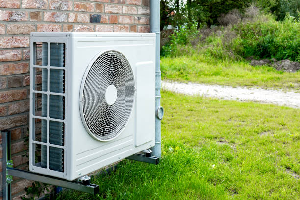 pompe à chaleur, solution de chauffage durable pour les maisons modernes. technologie de pompe à chaleur respectueuse de l’environnement devant une maison en briques. - pompe à chaleur photos et images de collection